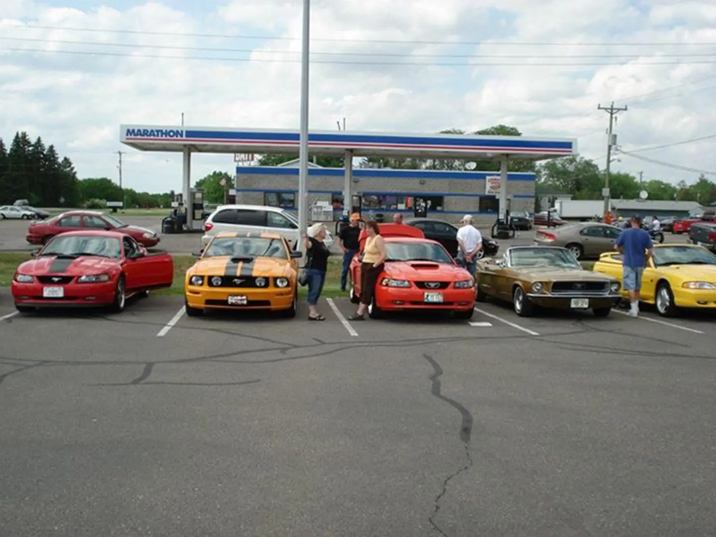People standing by parked sports cars.