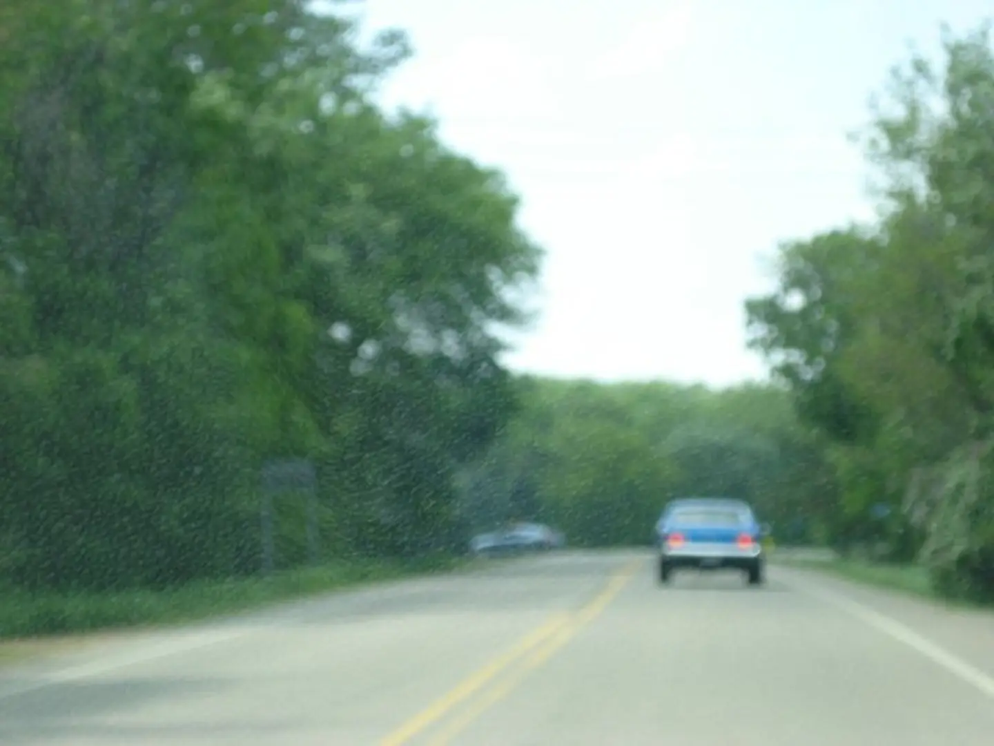 Out-of-focus vehicle on countryside road
