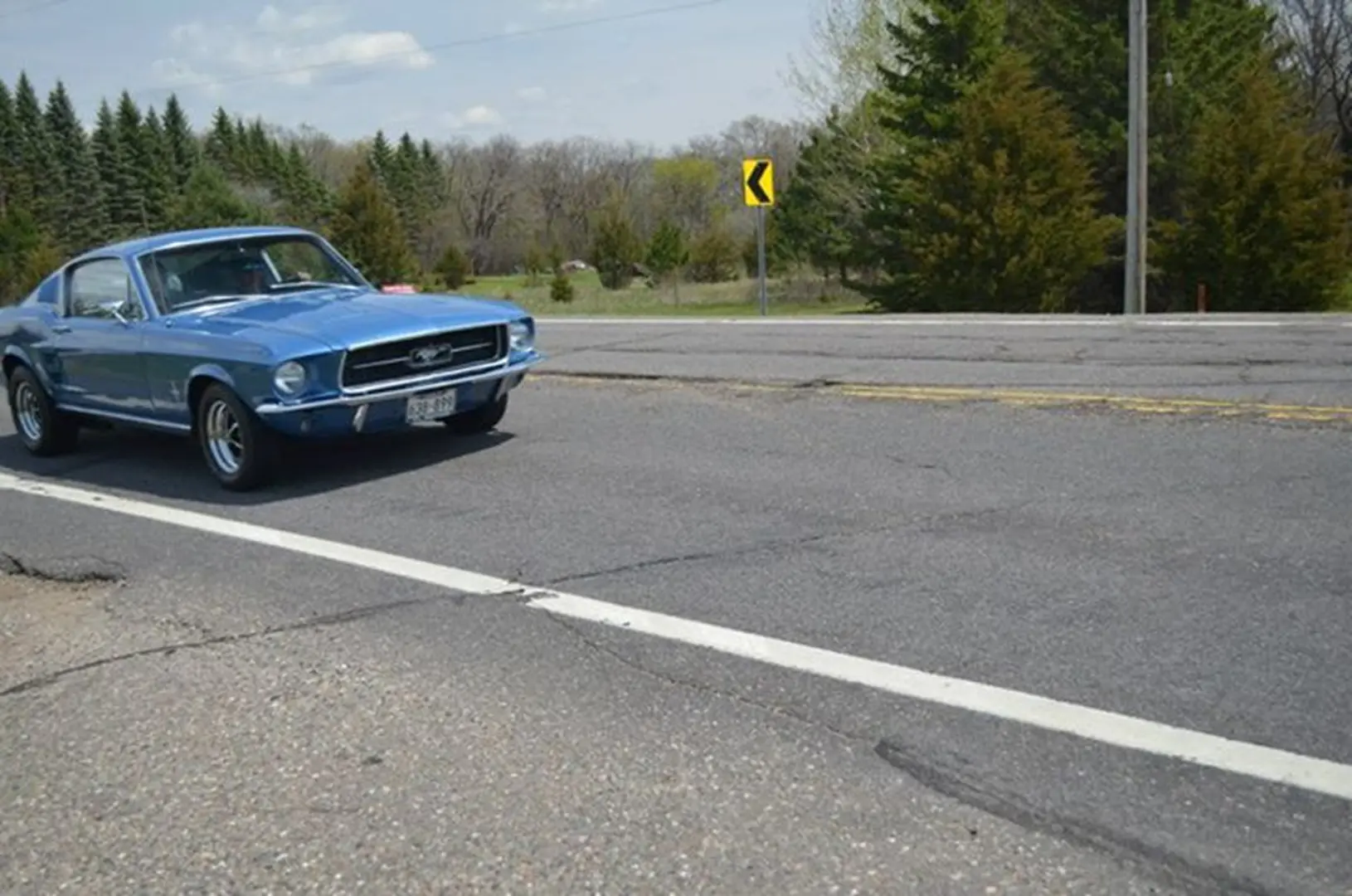 Blue classic car on rural road