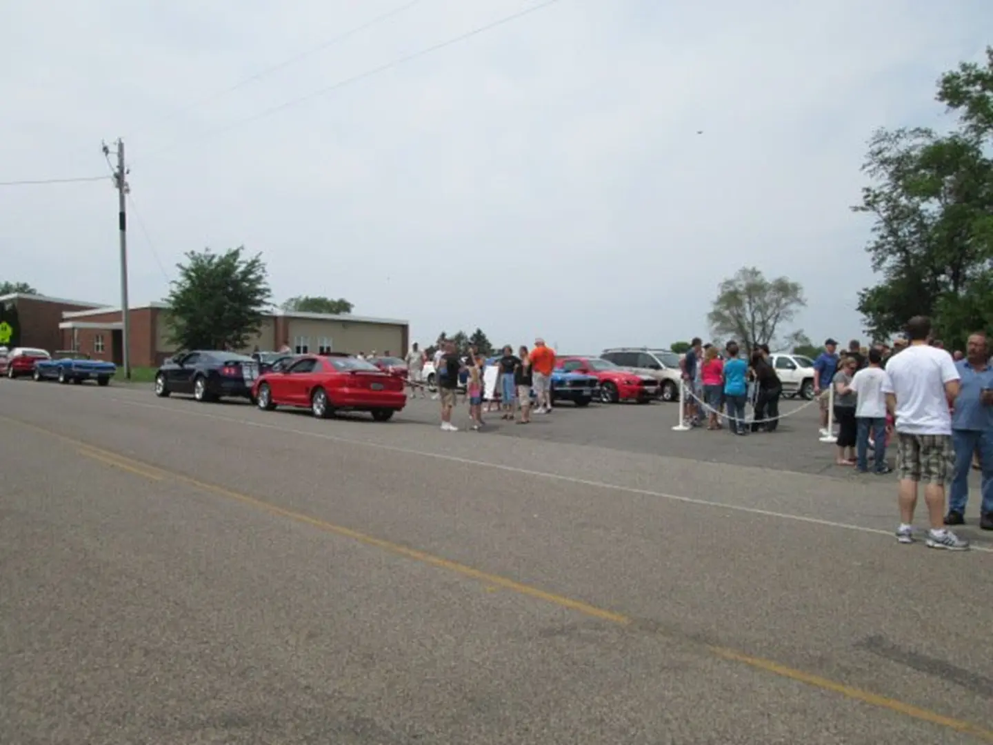 People gathering near parked cars on street