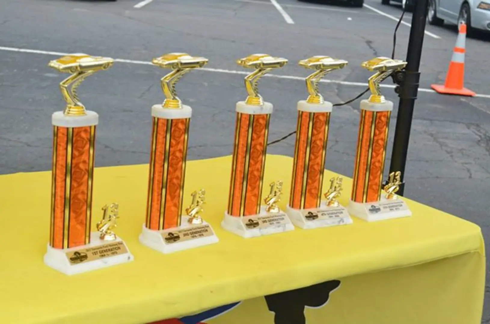Gold trophies on a yellow table