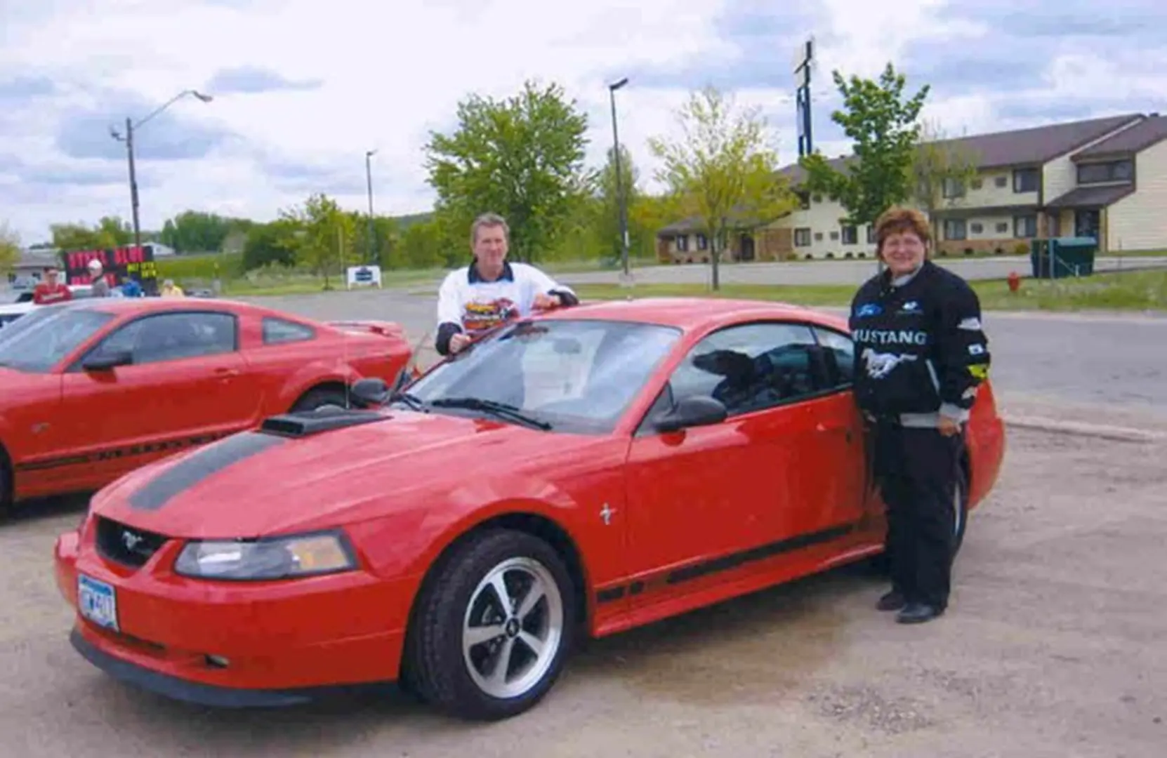 Red Mustang with two people