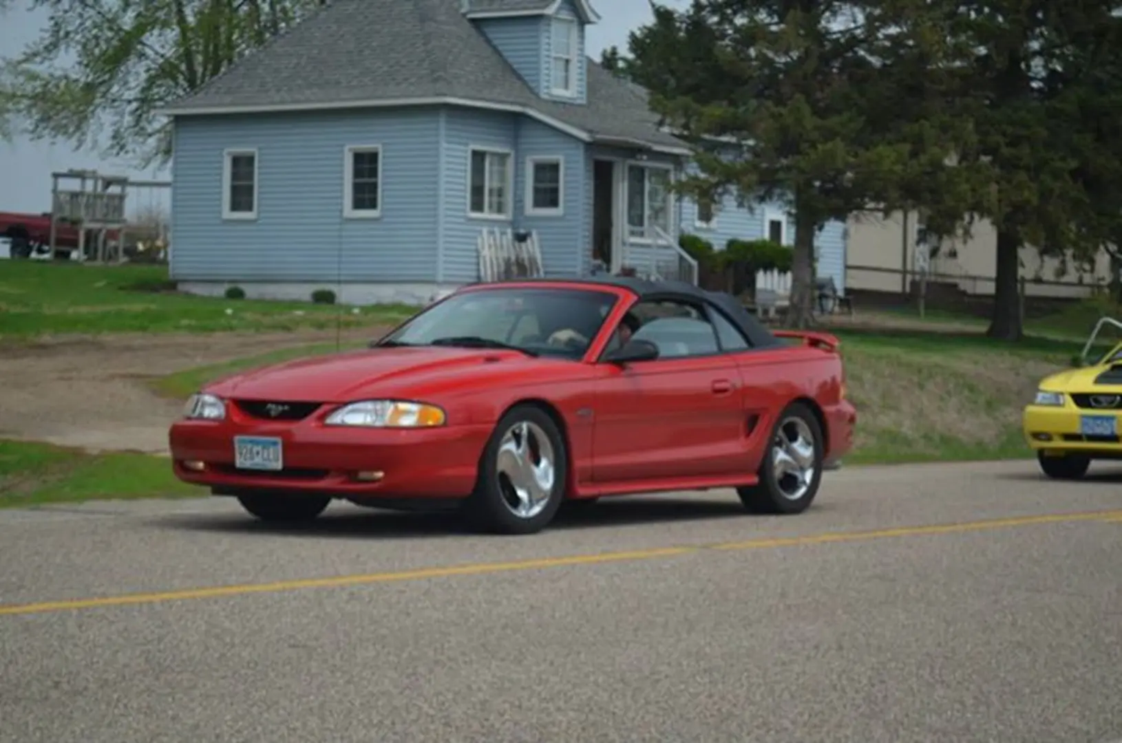 Red sports car near blue house