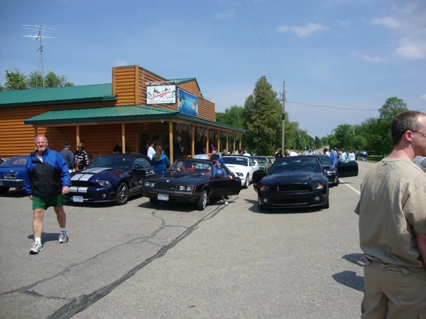 People walking by parked vintage cars