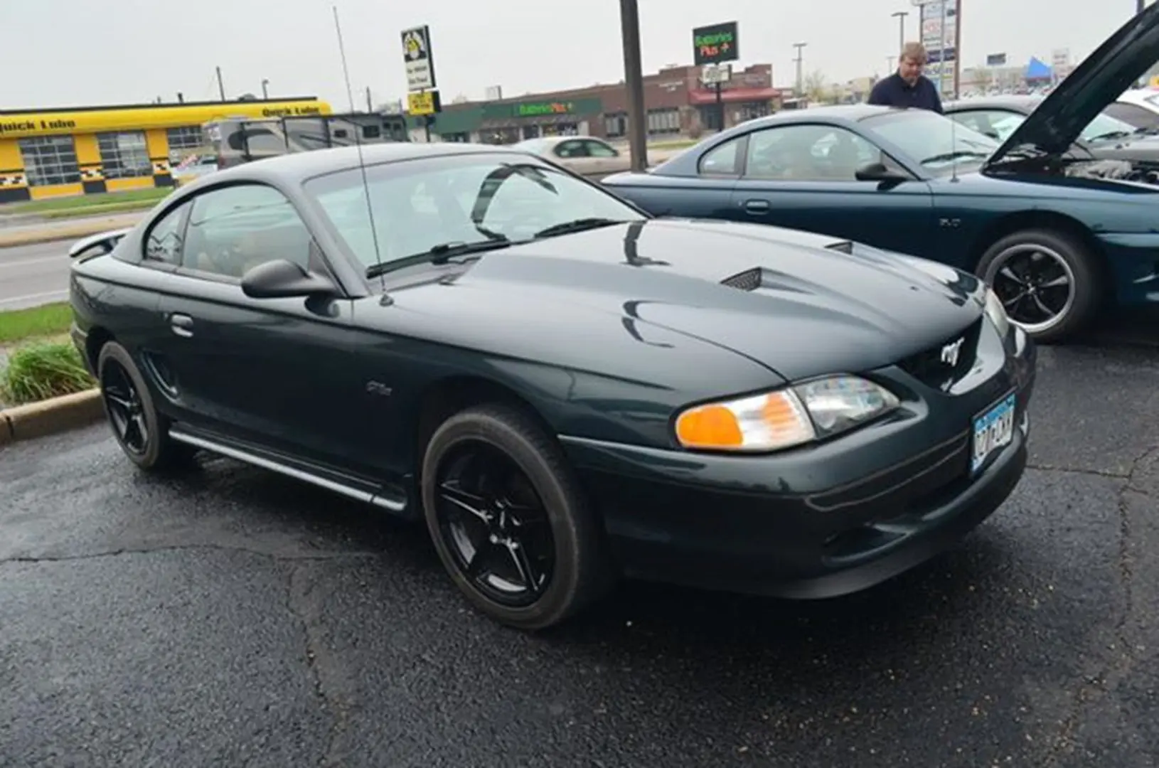 Black-wheeled Mustang on rainy day