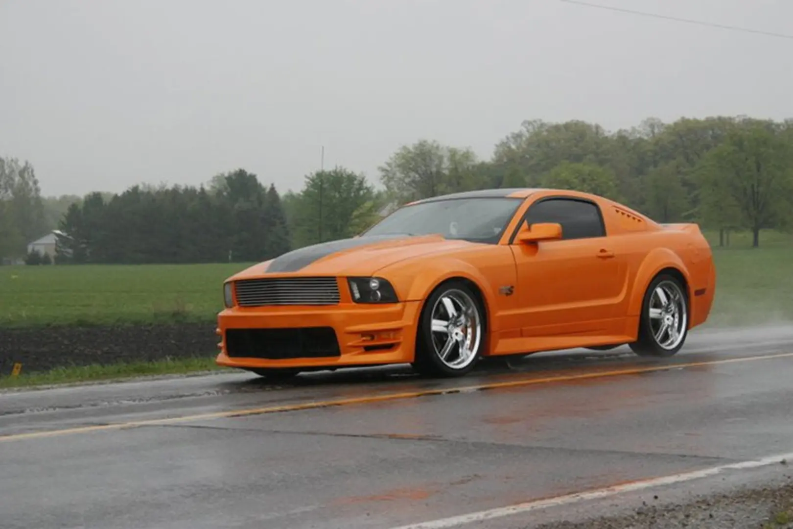 Orange car speeding on countryside road