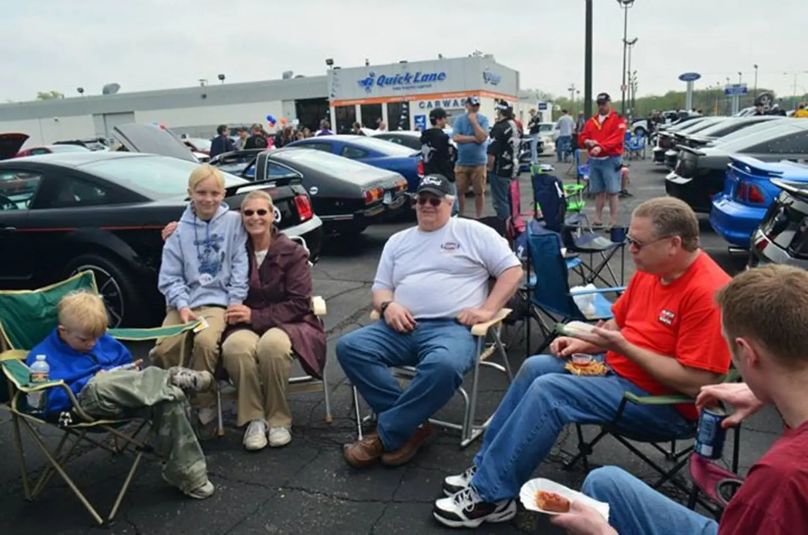 Group sitting in parking lot chairs