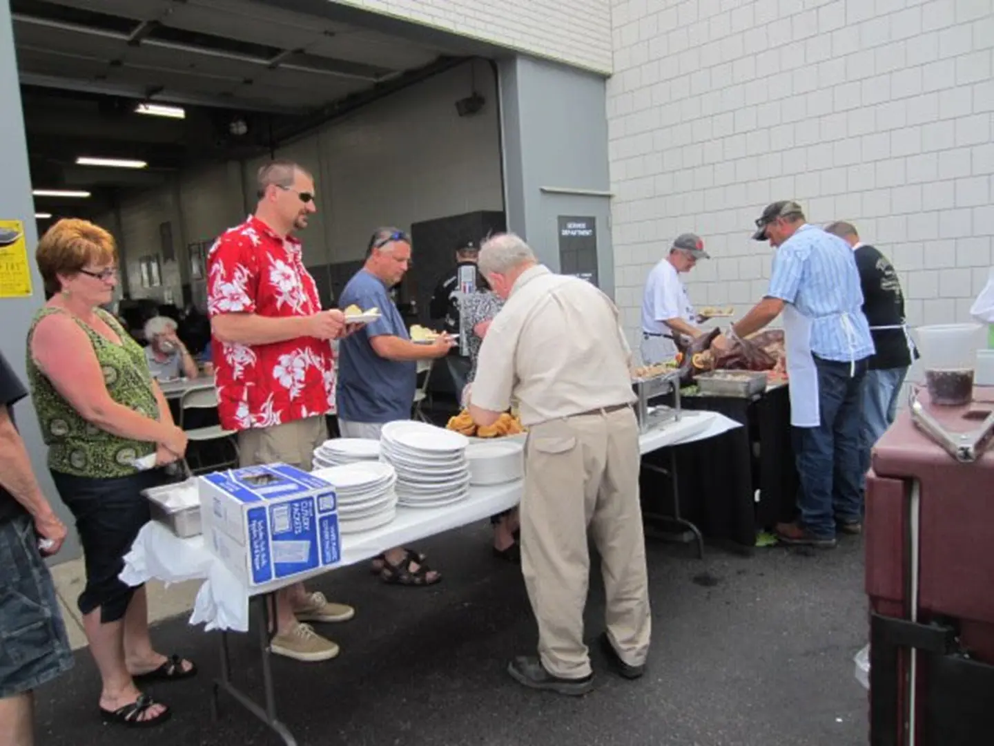 People serving food at outdoor event