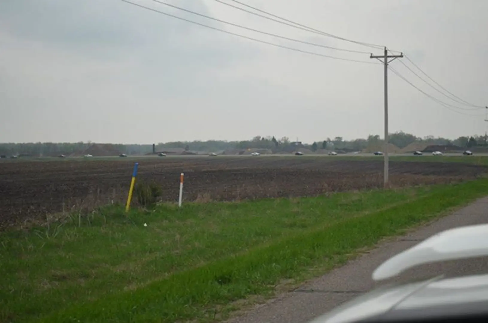 Overcast sky above farmland and road