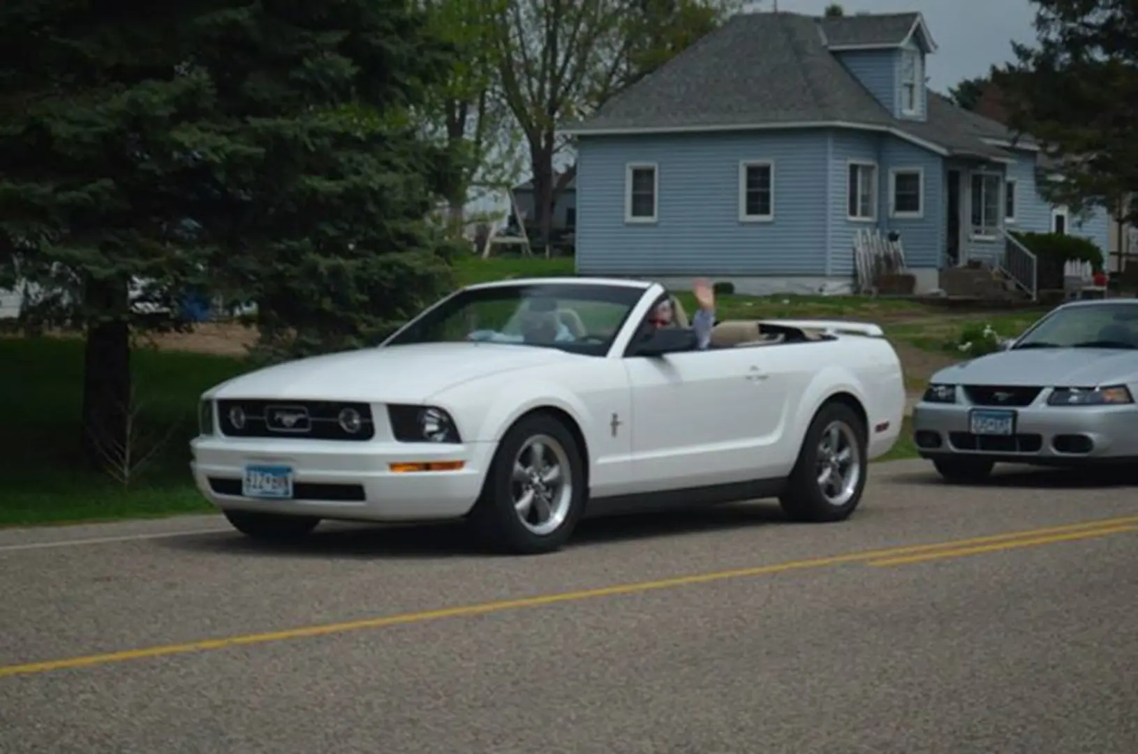 White convertible Mustang driving on street