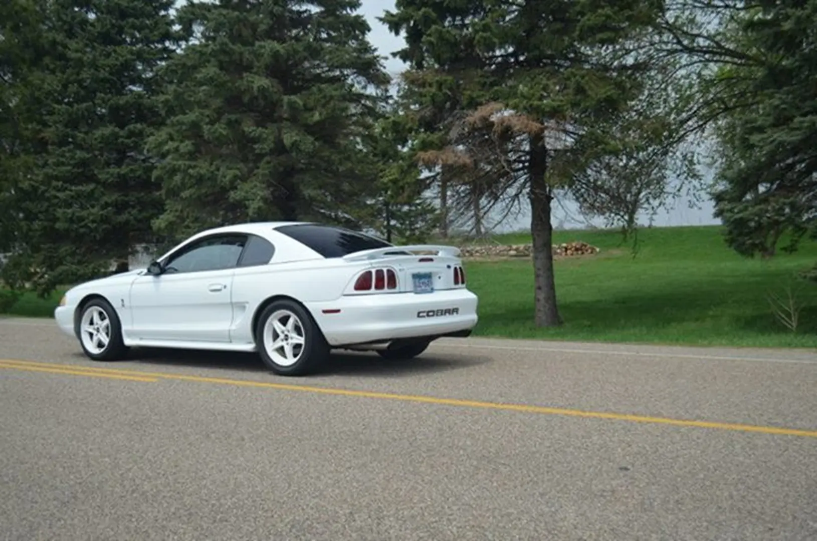 White car driving on a rural street
