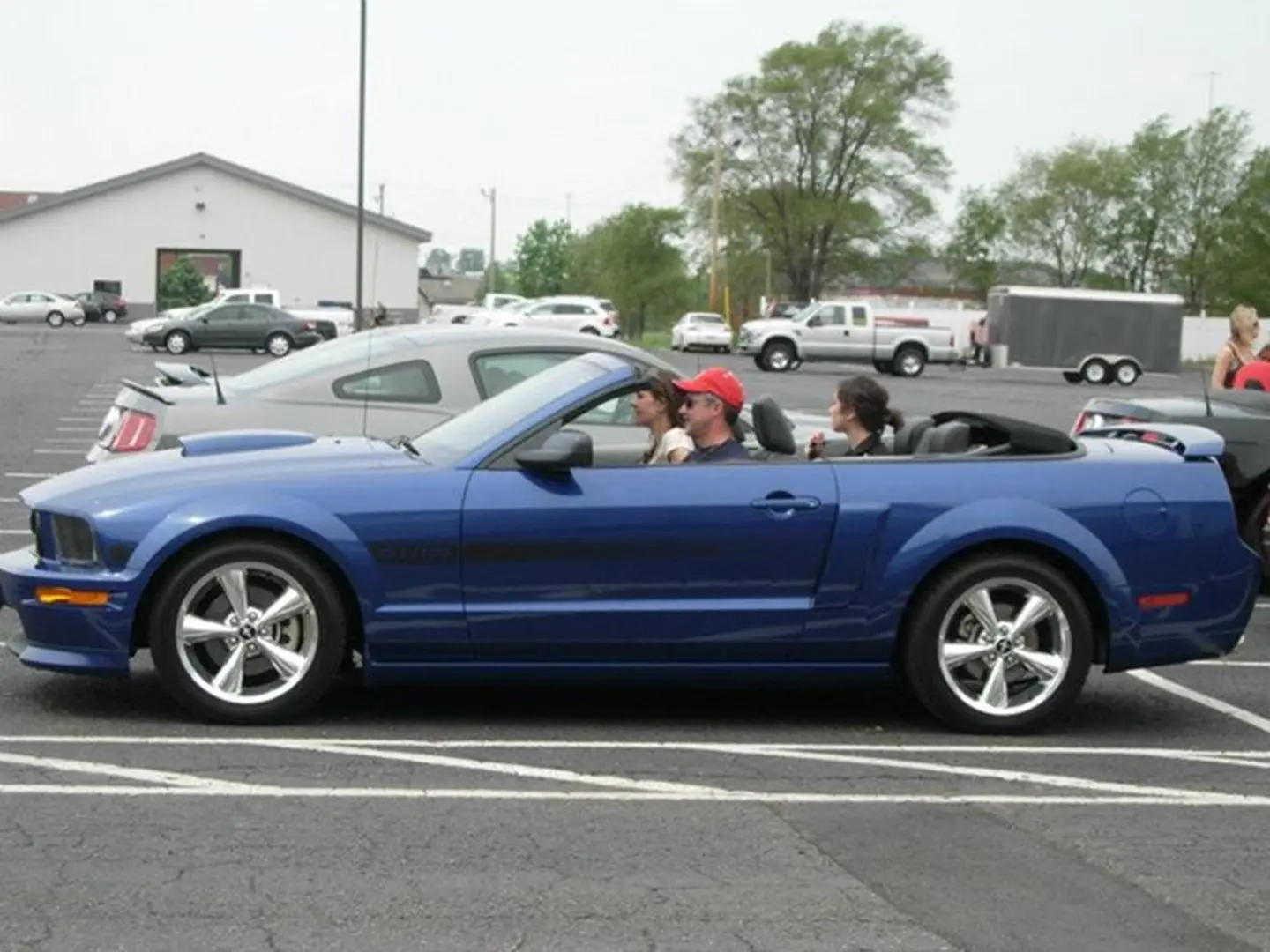Parked blue convertible with three passengers