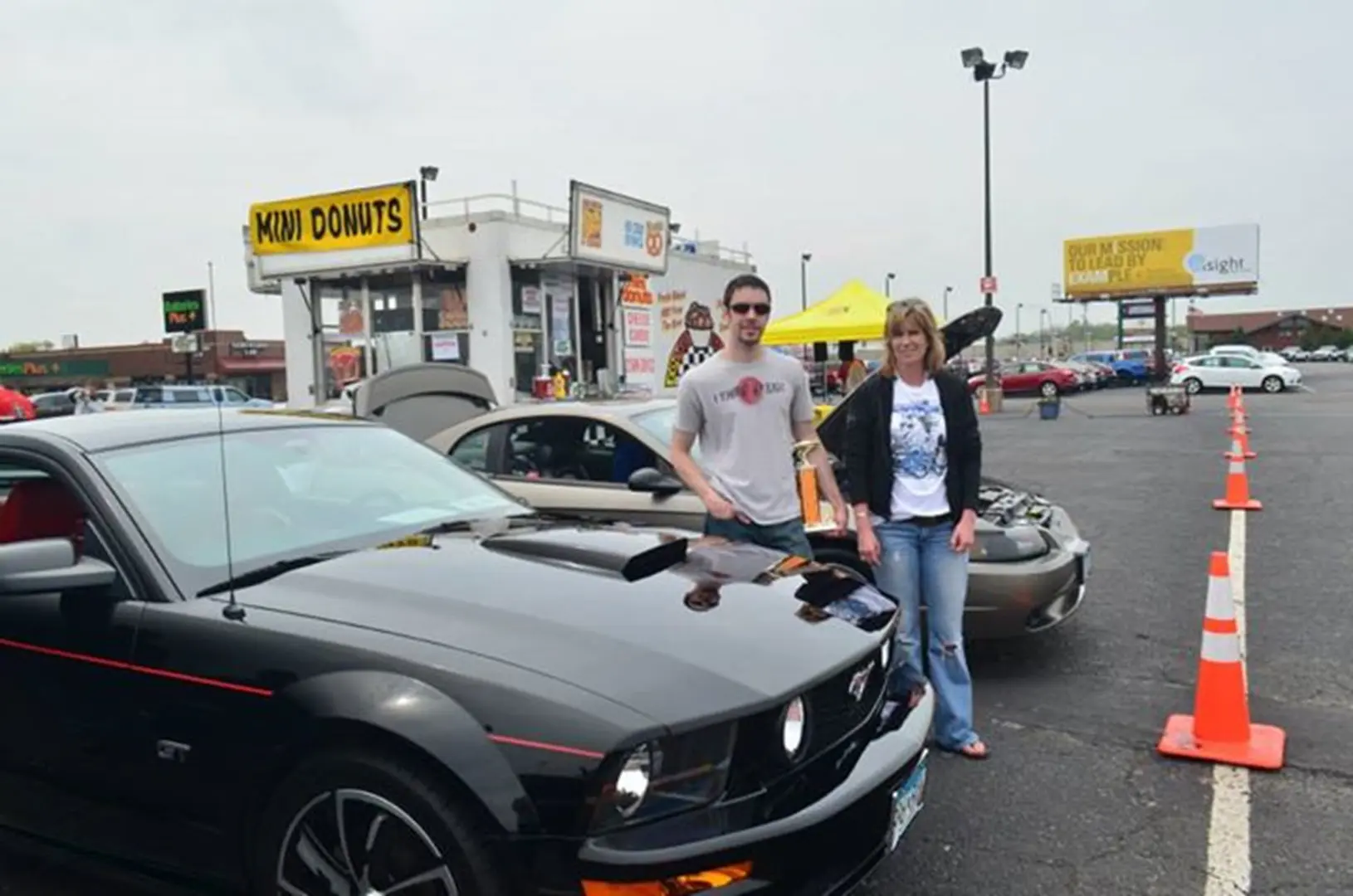 People standing by cars at car show