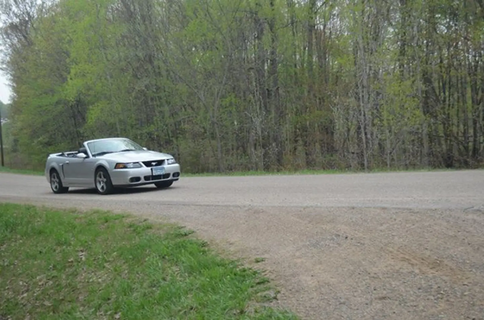 Silver convertible driving on rural road