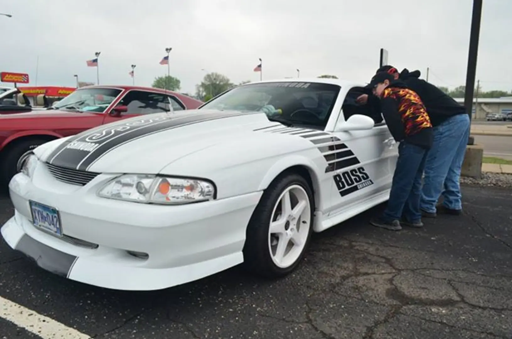 Two people inspecting a white car