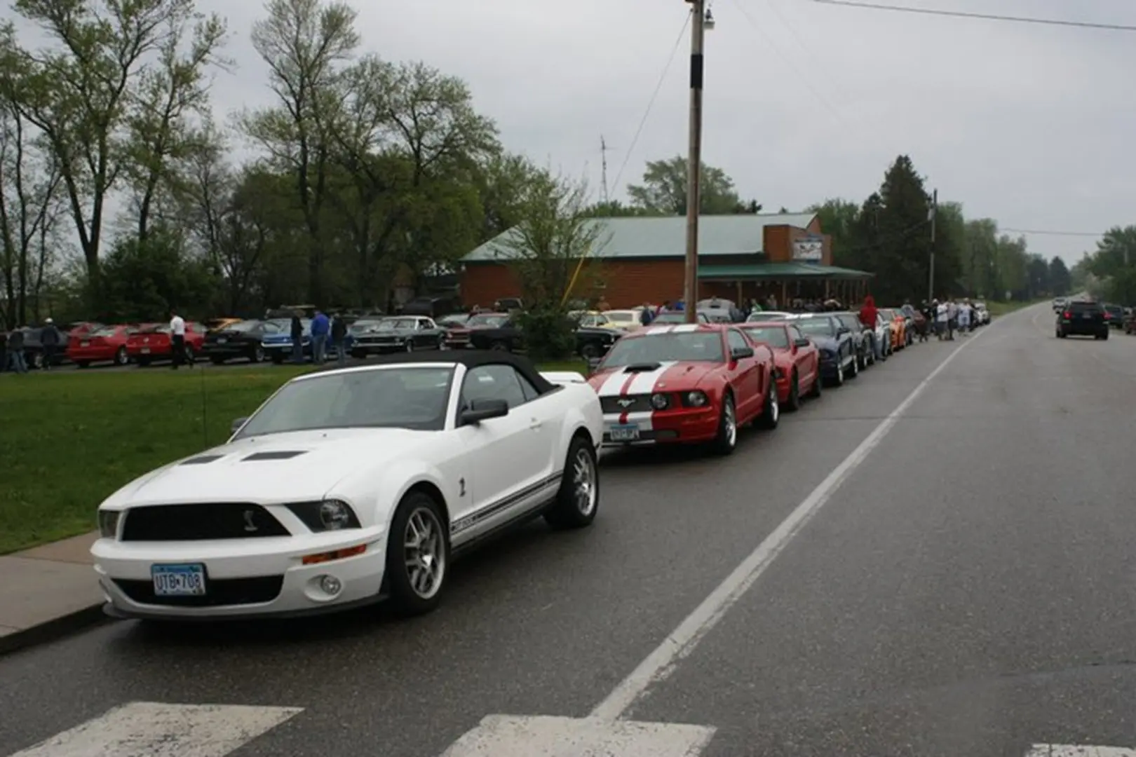 Cars parked along roadside under cloudy sky