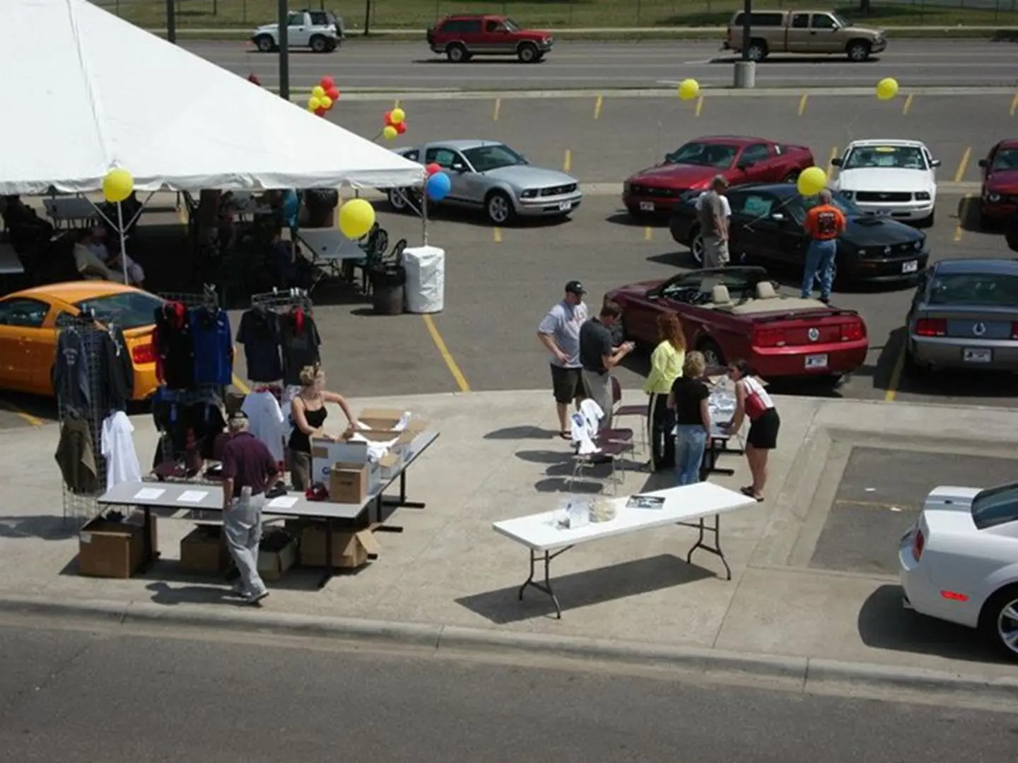 People browsing cars and merchandise