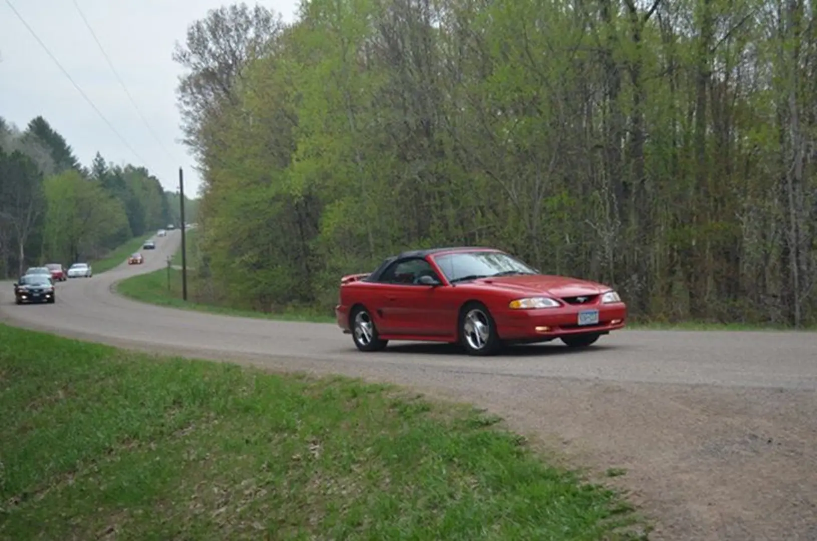 Red car driving on a rural road