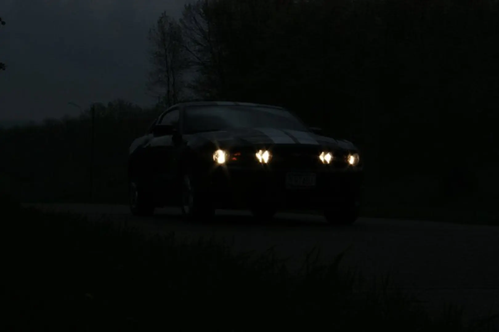 Dark road with illuminated car