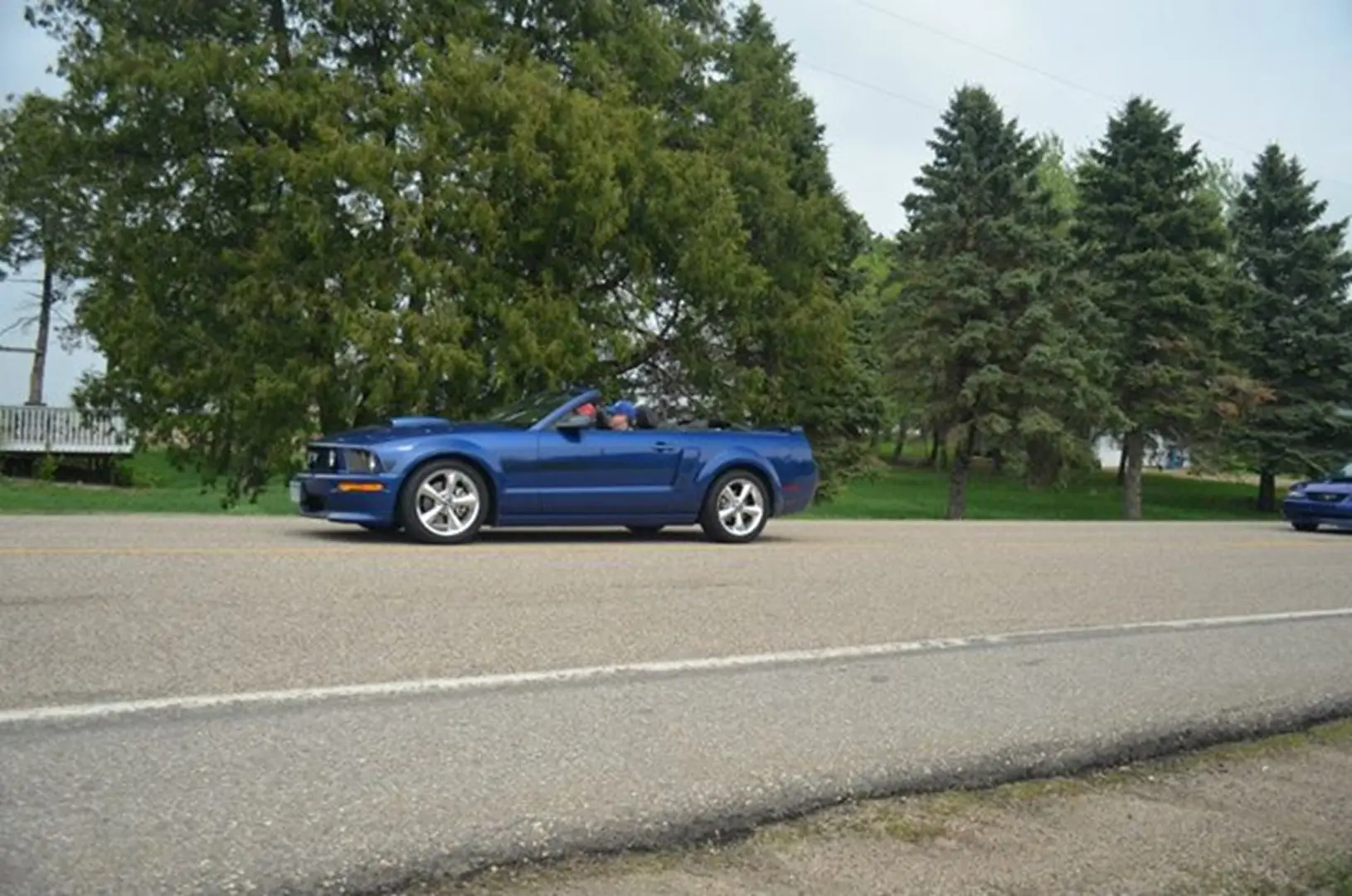 Blue convertible driving on rural road