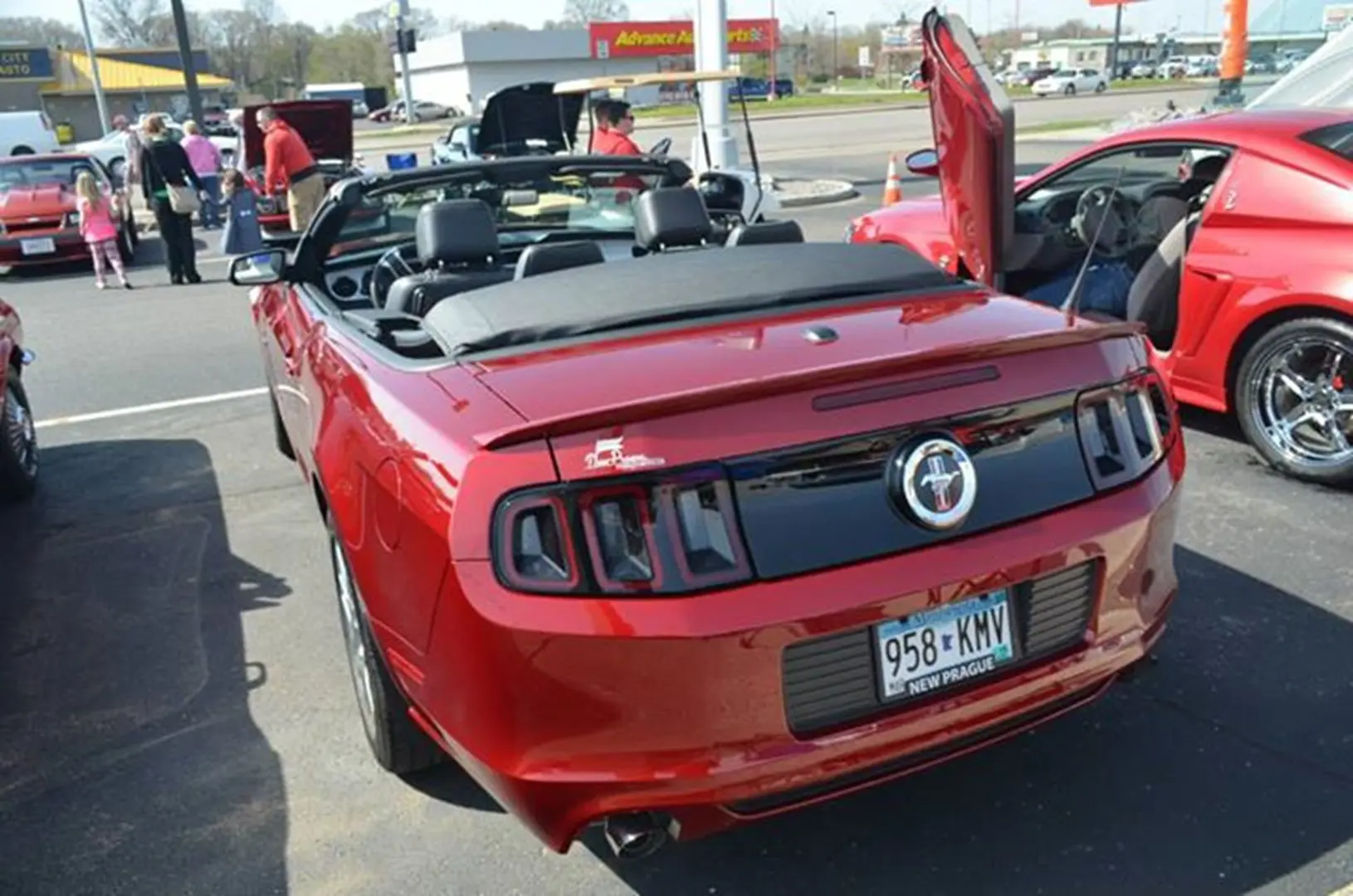Red convertible car at outdoor auto show.