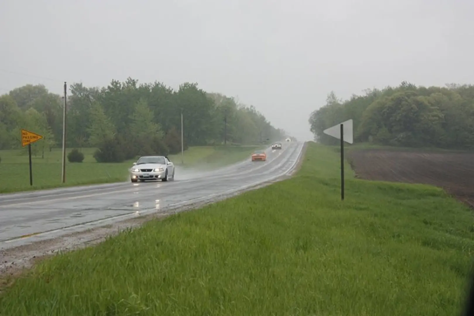 Wet highway with green fields.