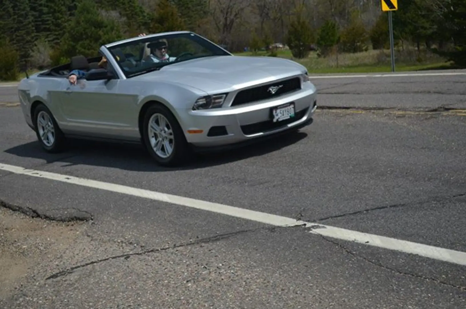 Driving Mustang convertible in sunlight