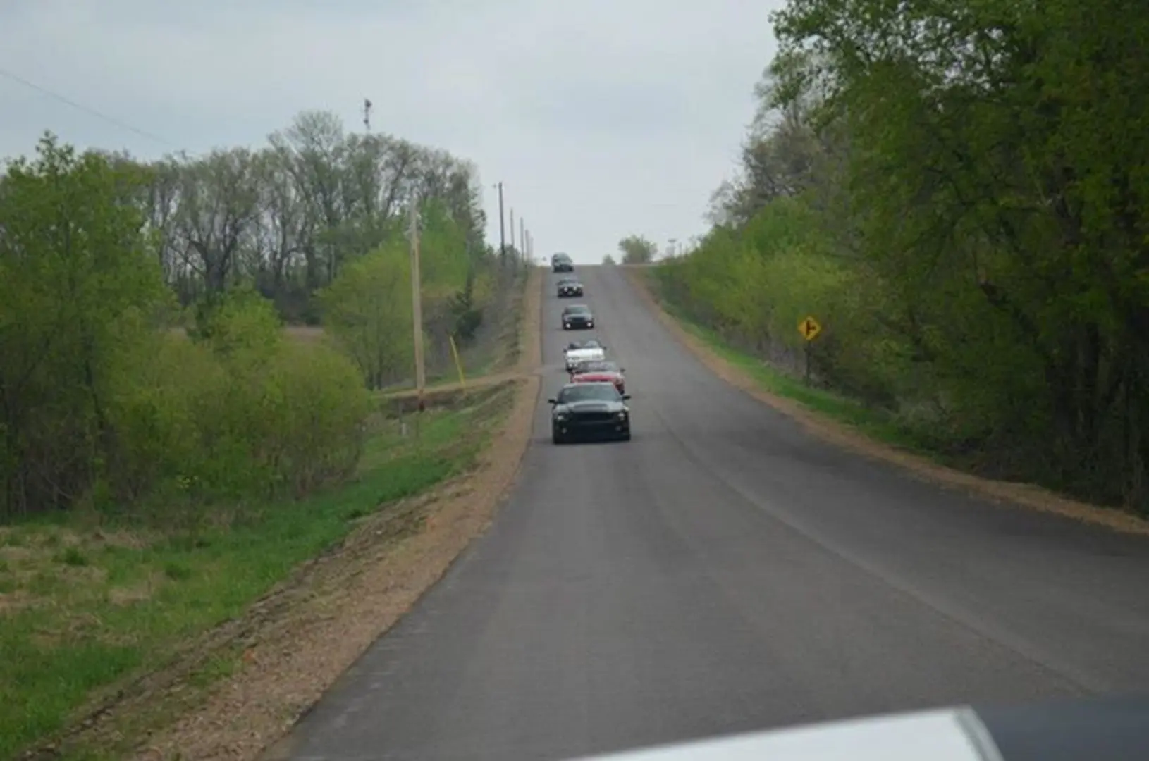 Cars ascending a hill on a road