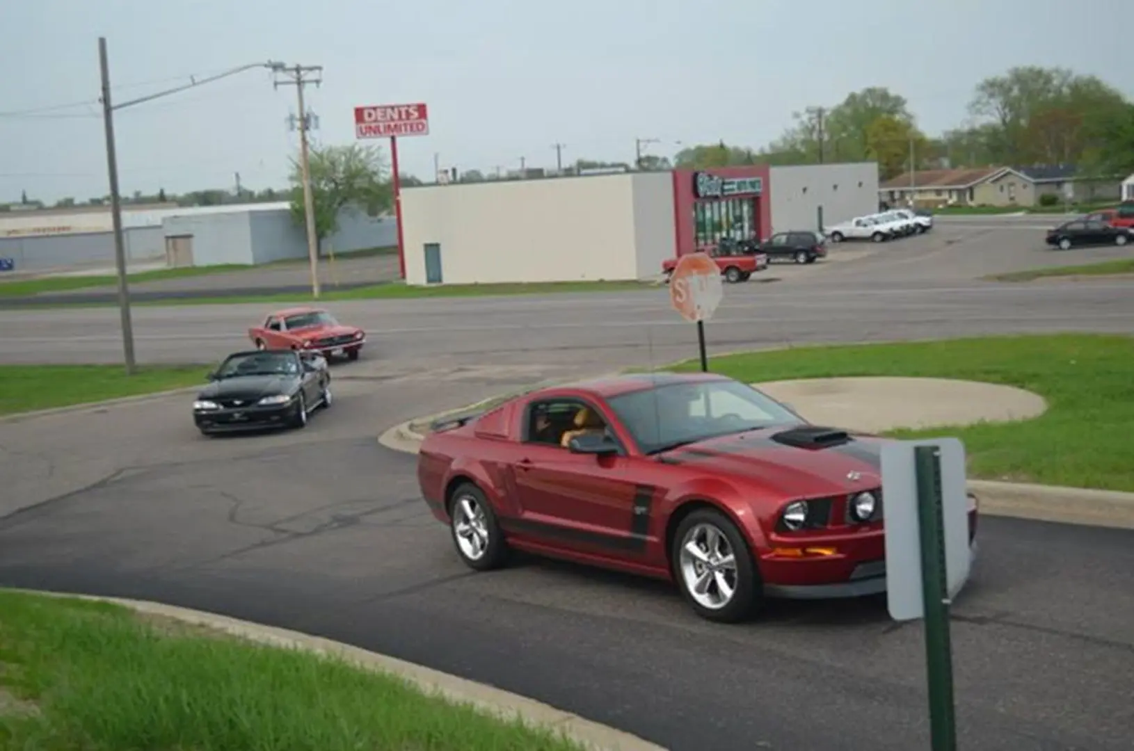 Three cars driving near parking lot