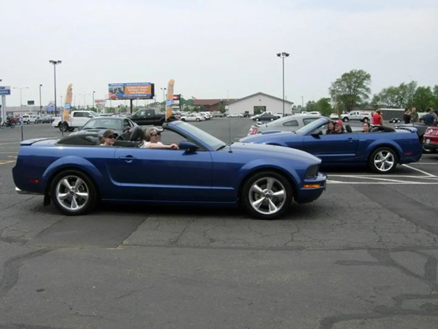 Two blue convertibles in parking area
