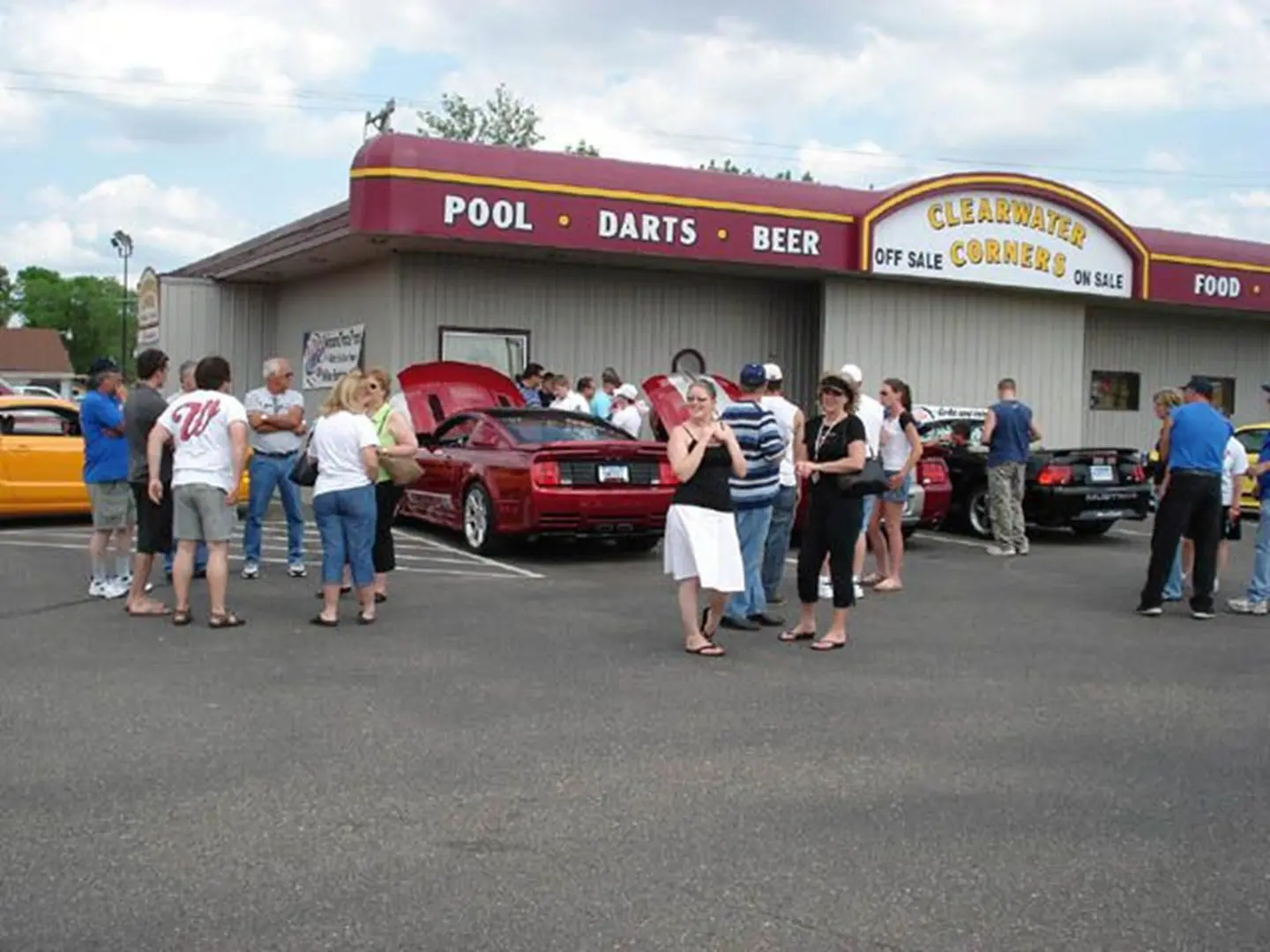 Crowd examines cars in parking lot