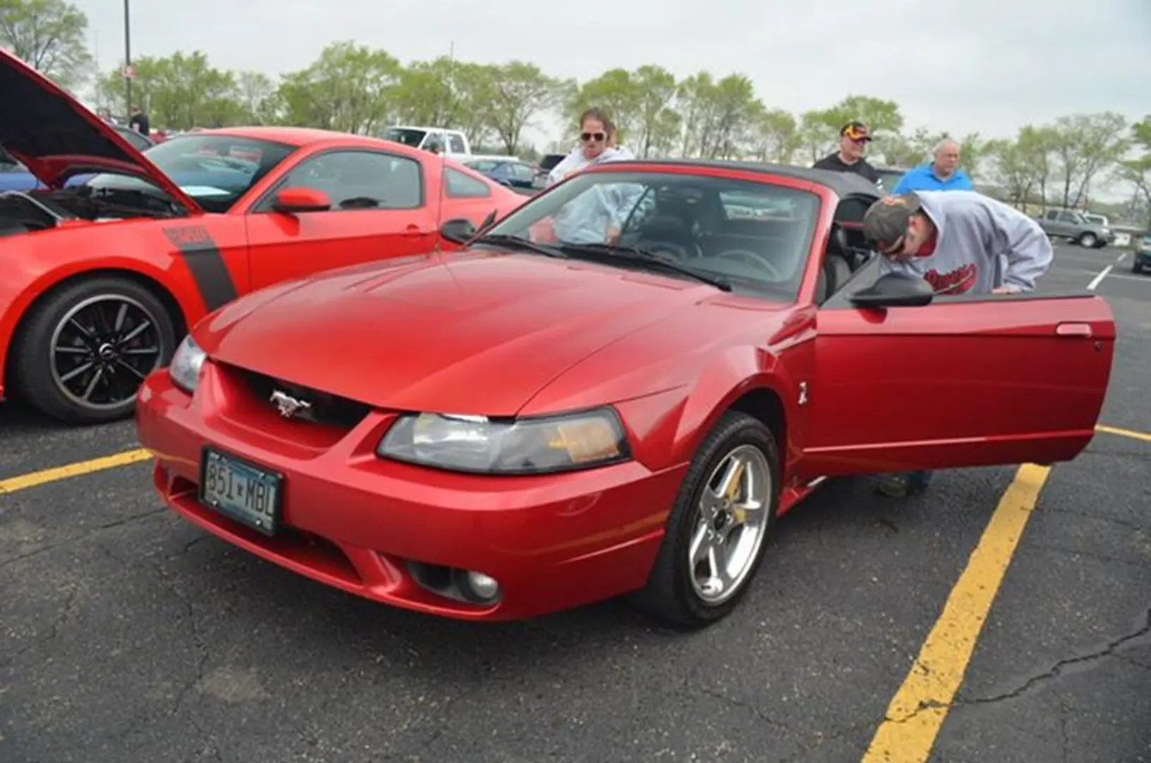 Red Mustang convertible at a car show