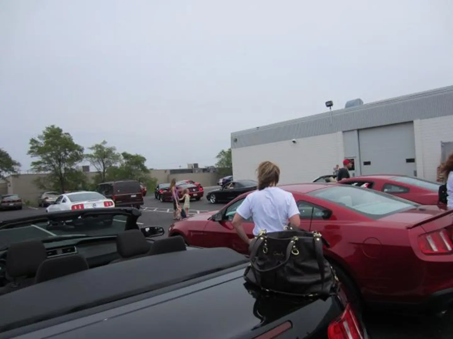 People around parked cars in lot
