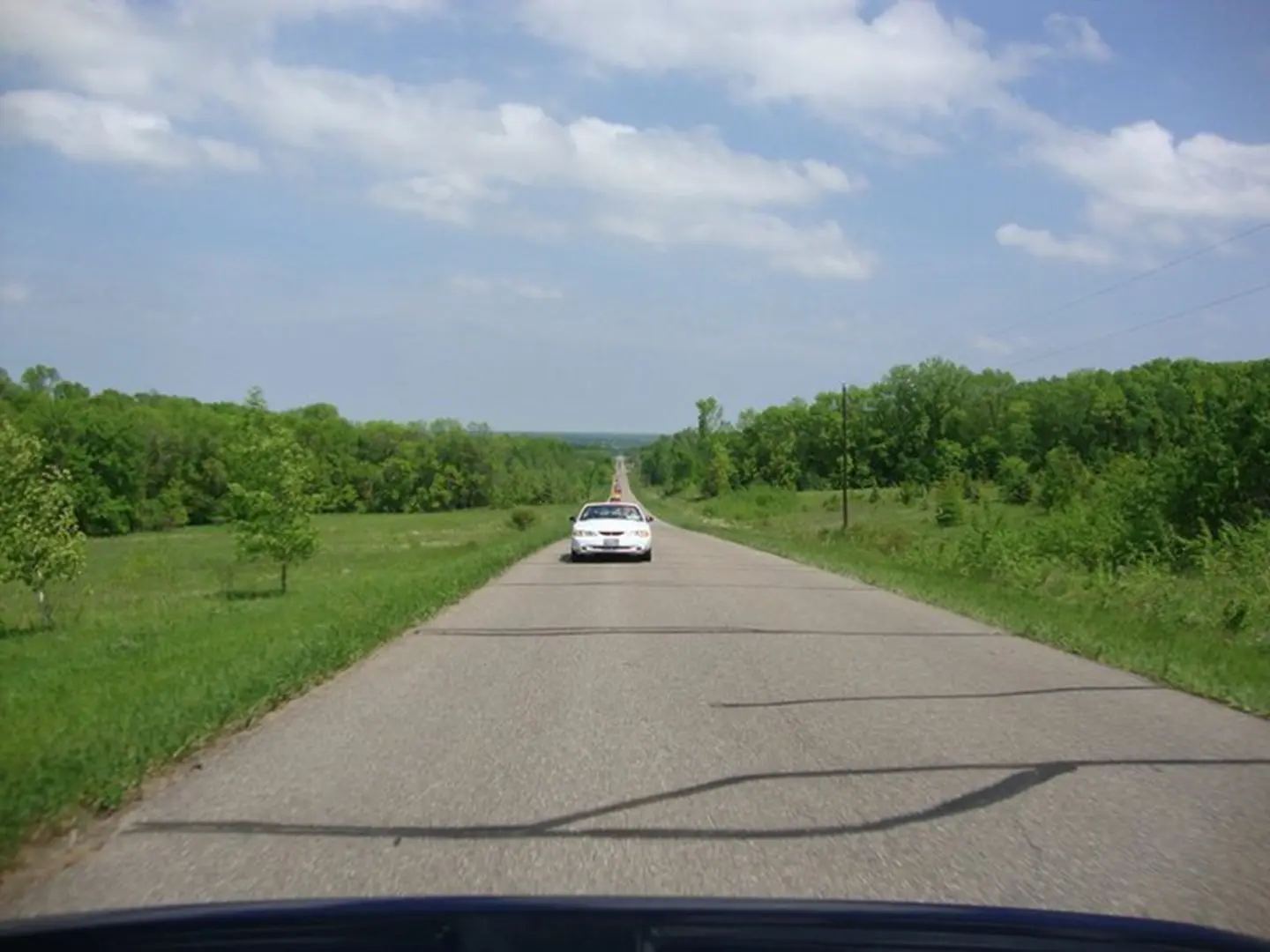 Police car driving through green countryside