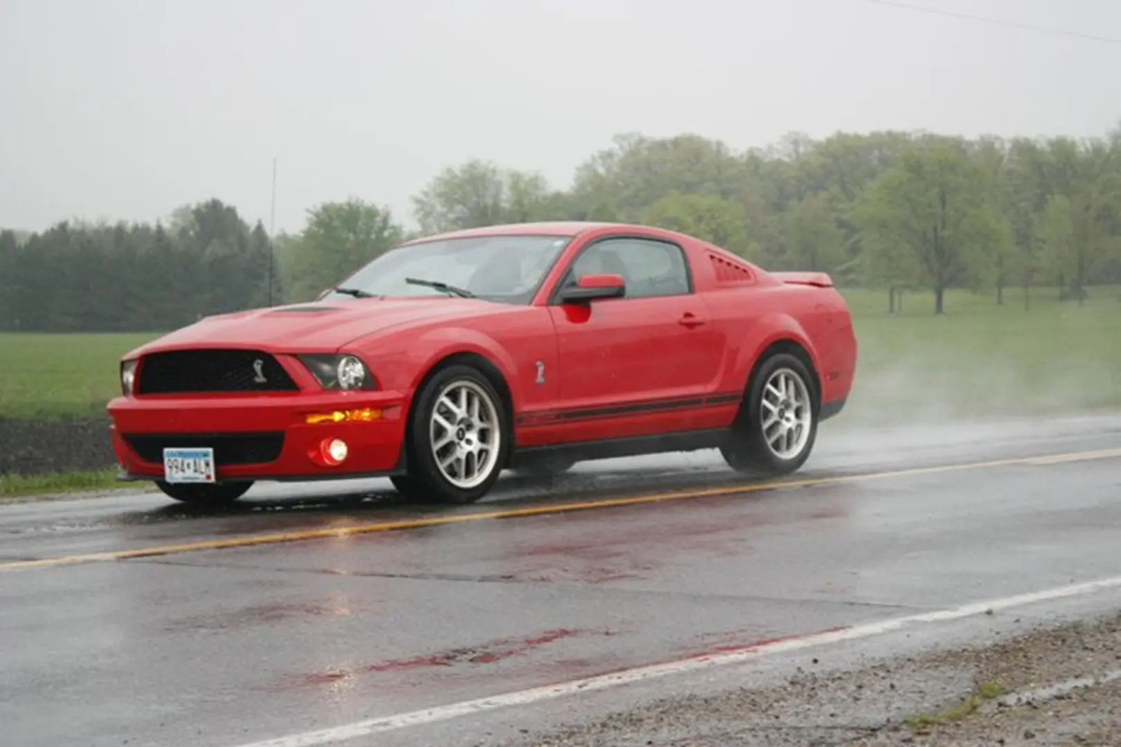Mustang cruising through rain-soaked street