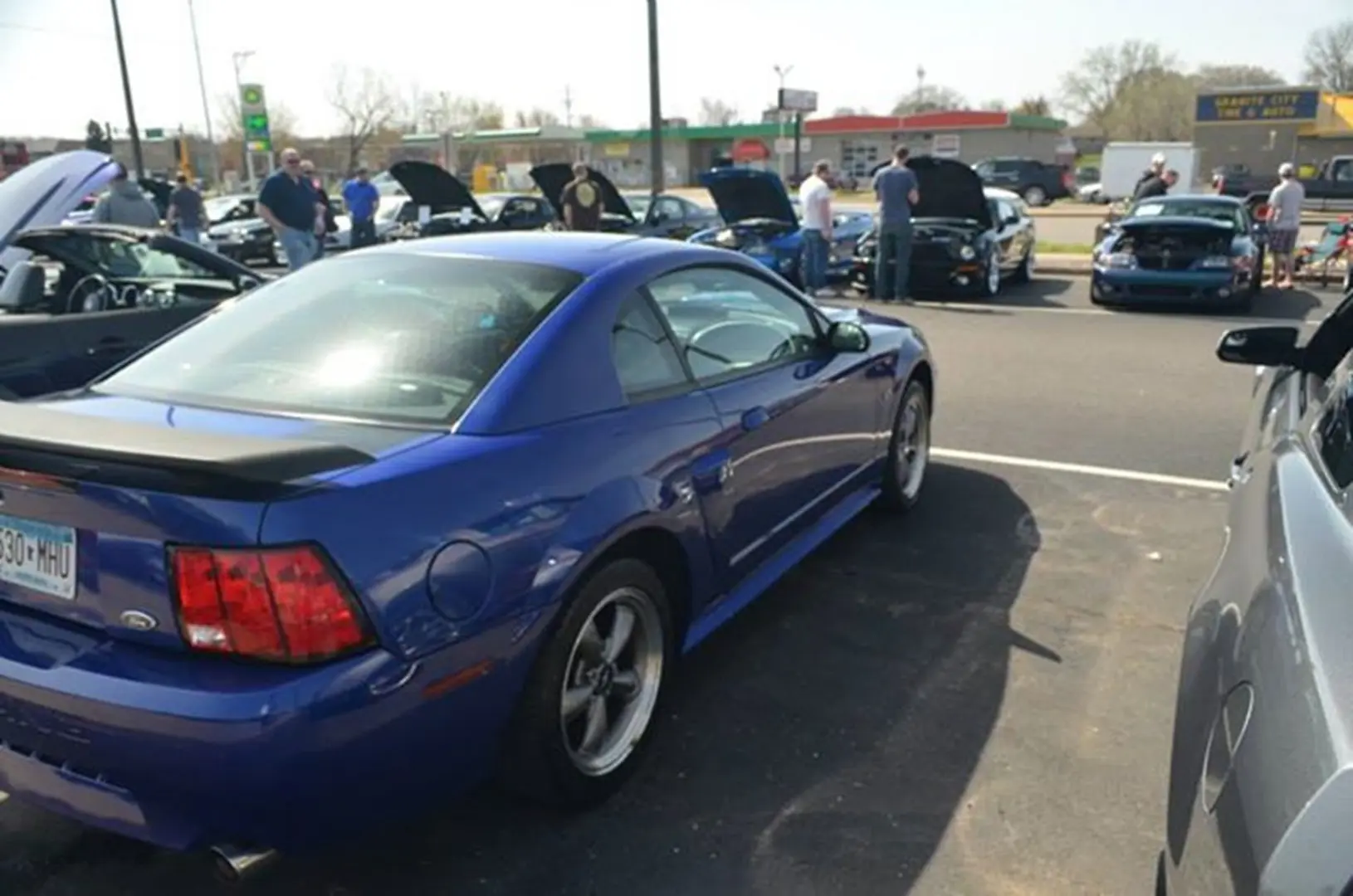 Outdoor car show with blue sports car
