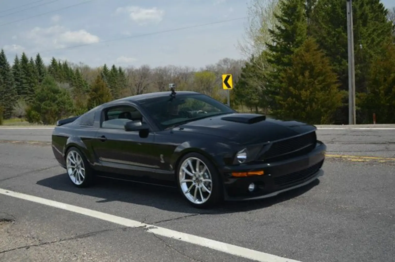 Black coupe near forested area