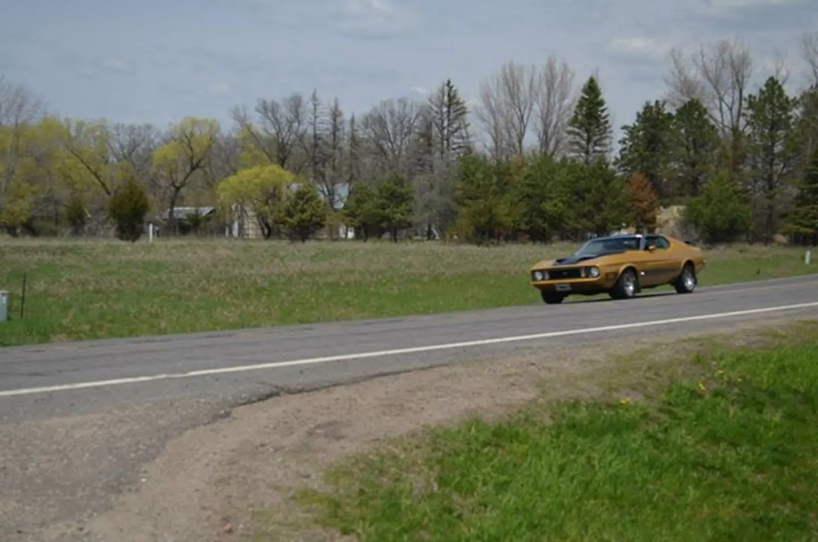 Yellow car cruising through scenic landscape