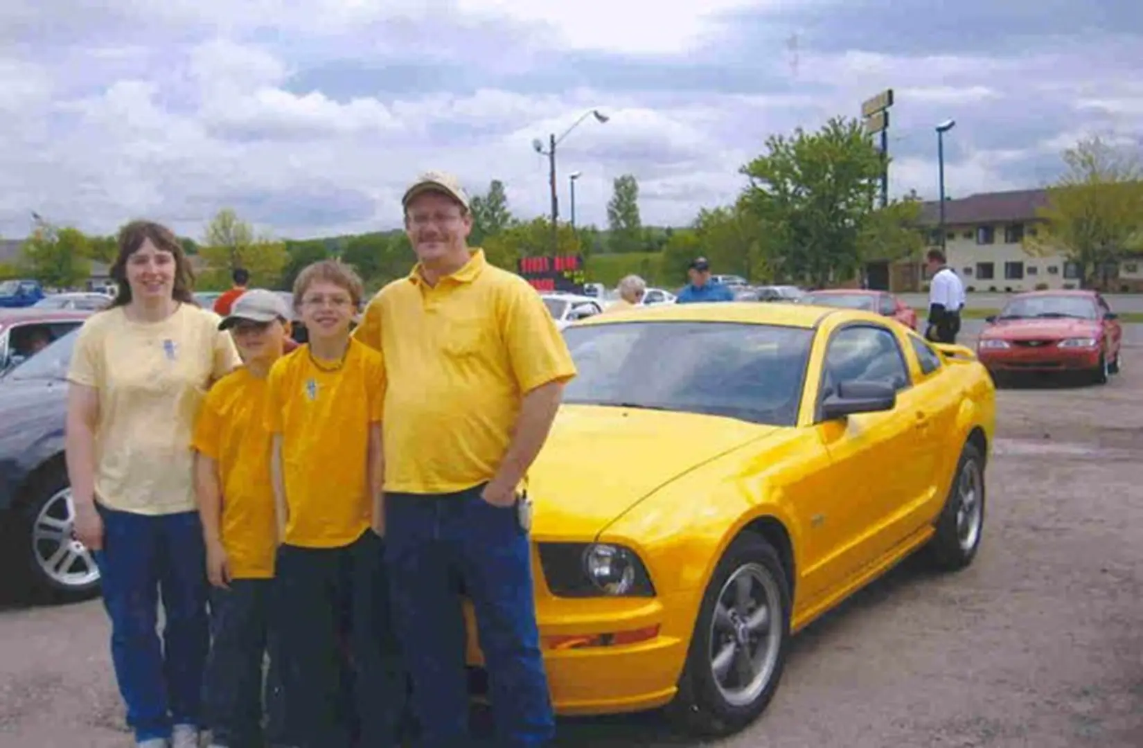 Family posing by yellow sports car
