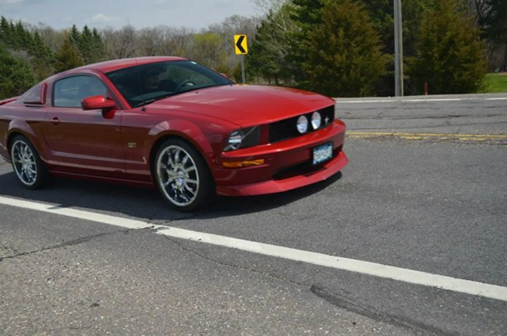 Shiny red car driving on road