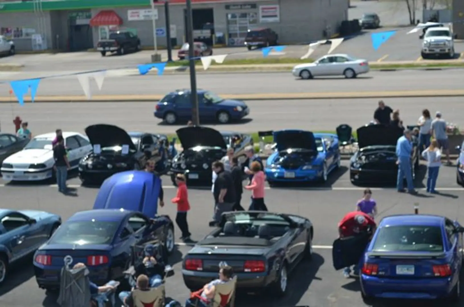 People admiring parked cars