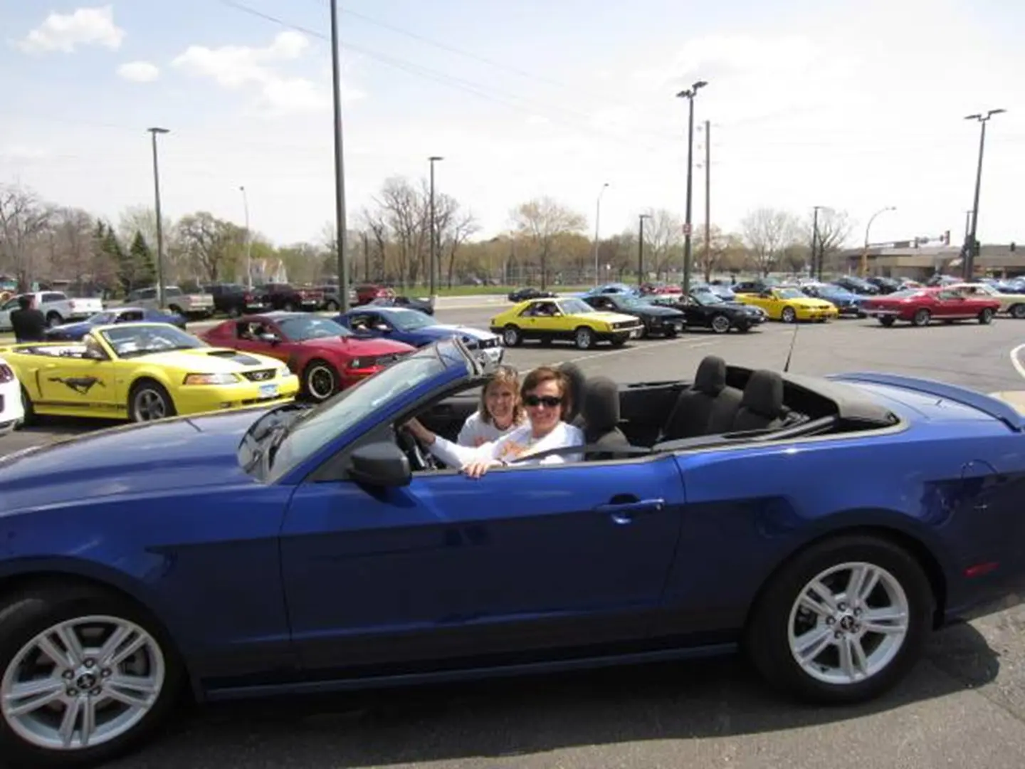 Smiling pair in a blue convertible.
