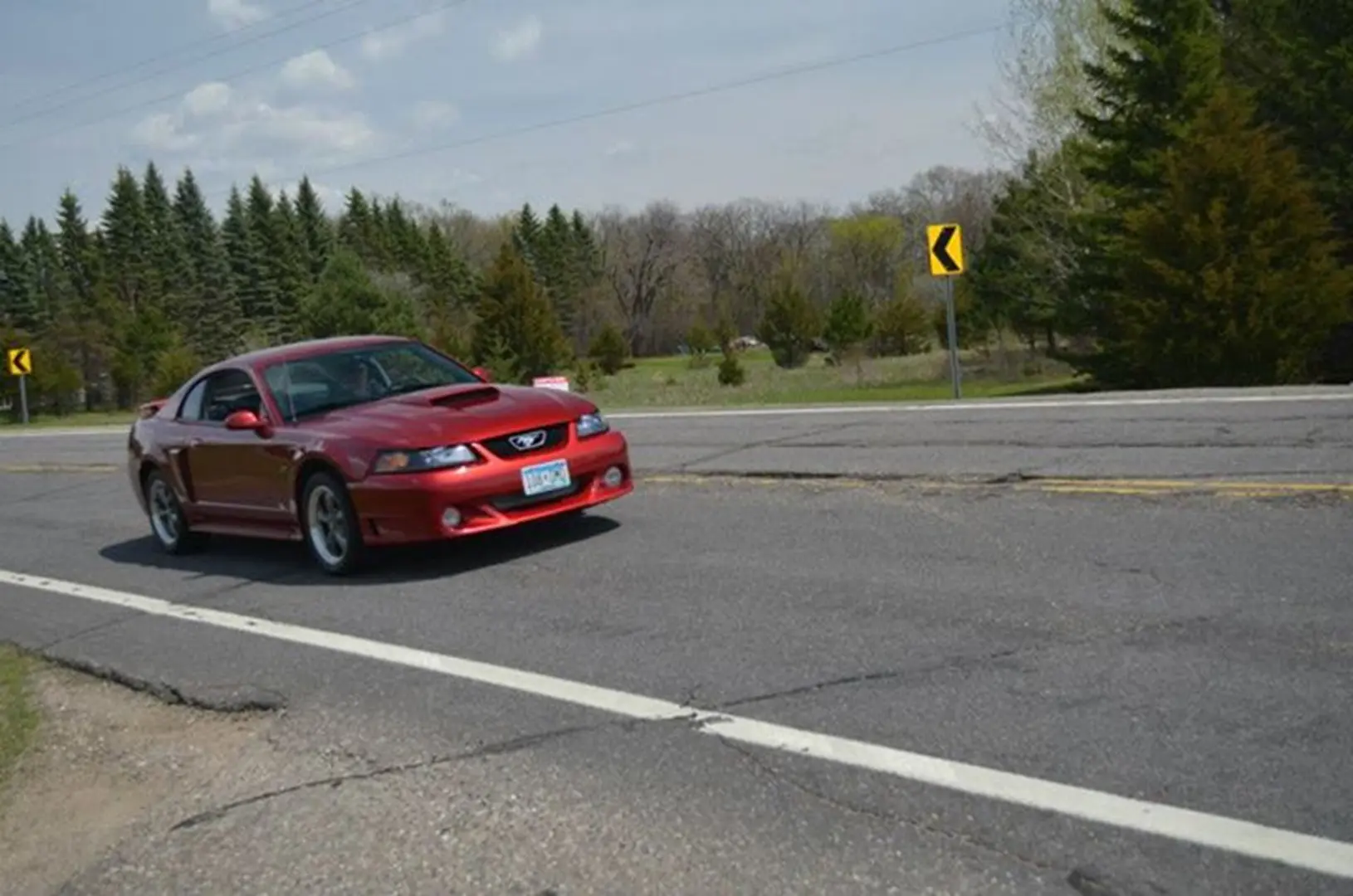 Car driving past forested area