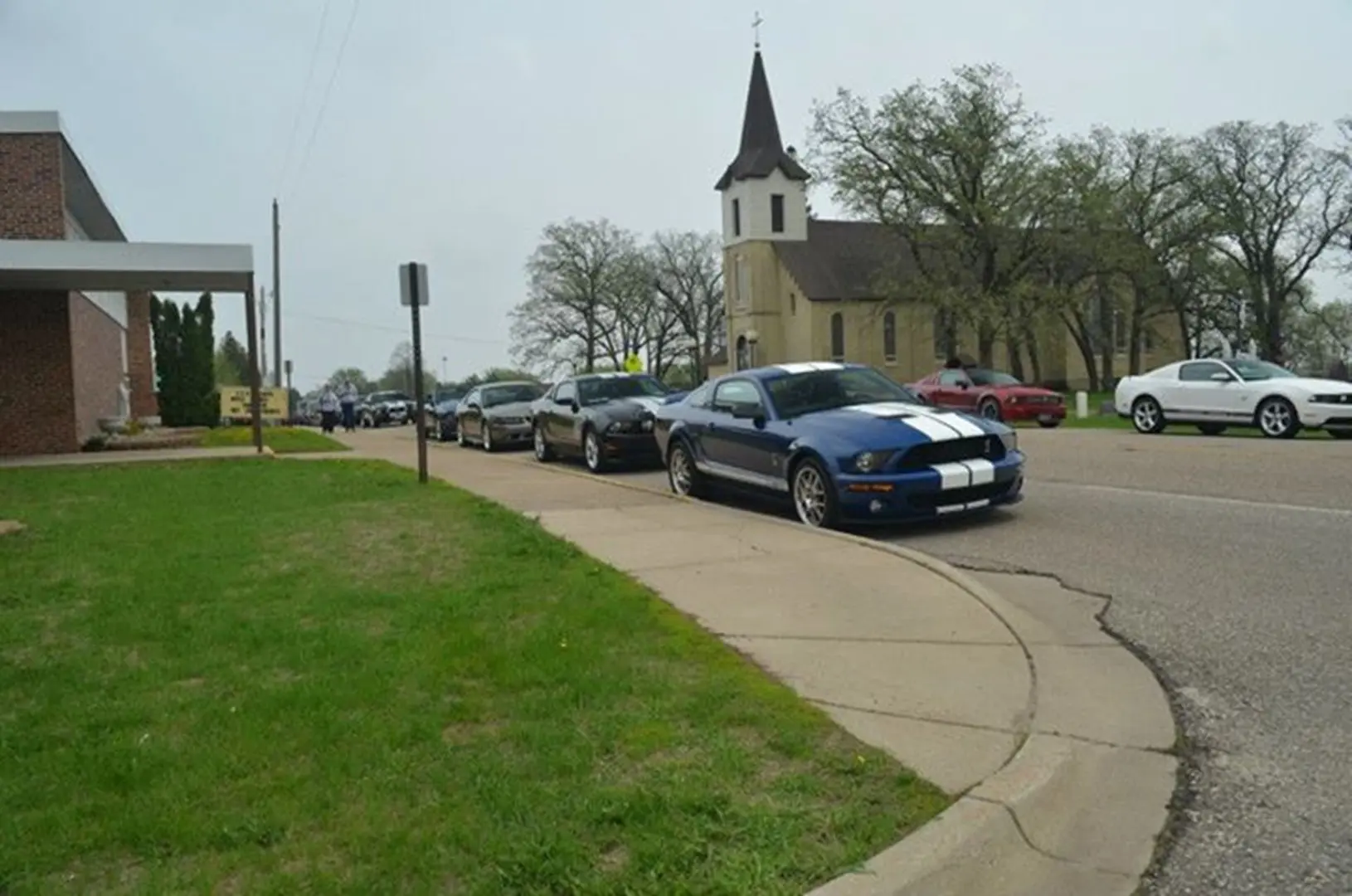 Line of cars by a church.