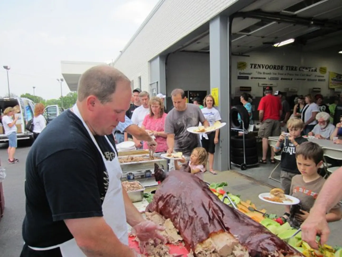 Man carving roast pig at gathering