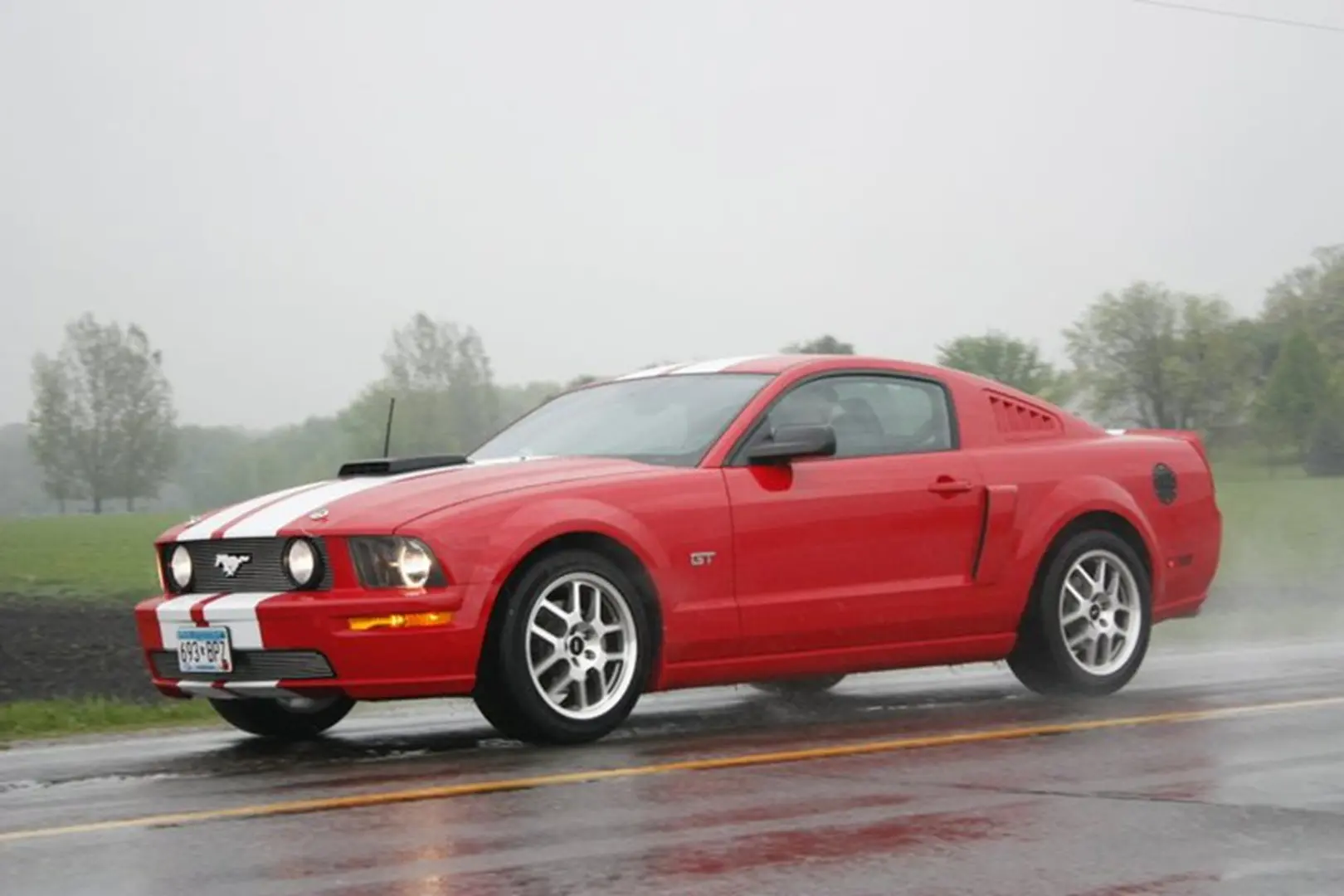 Red car with white stripes speeding