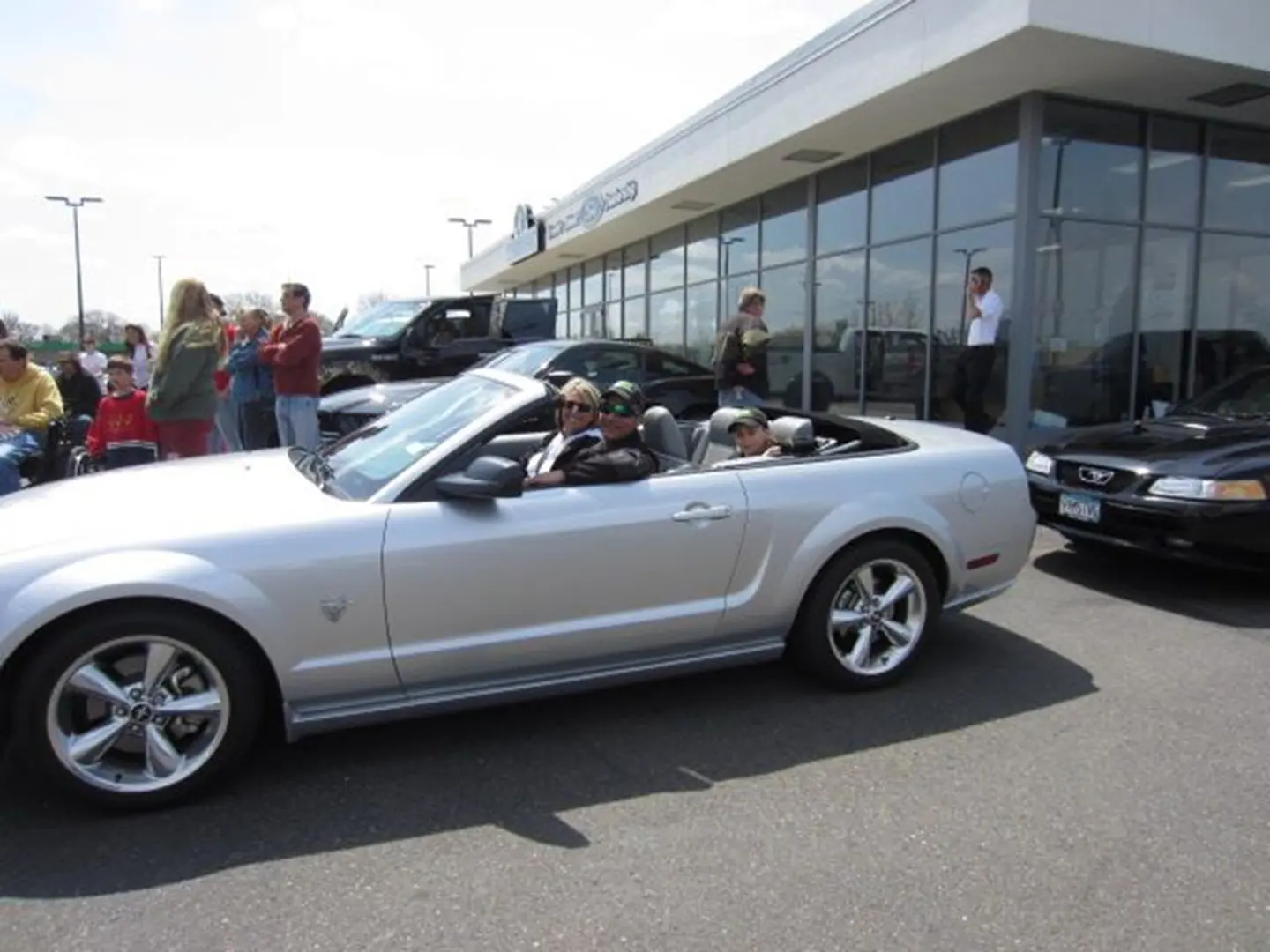 Car enthusiasts gathered at dealership event