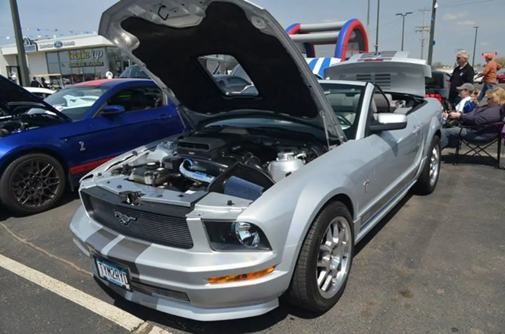 Silver convertible sports car with hood open.