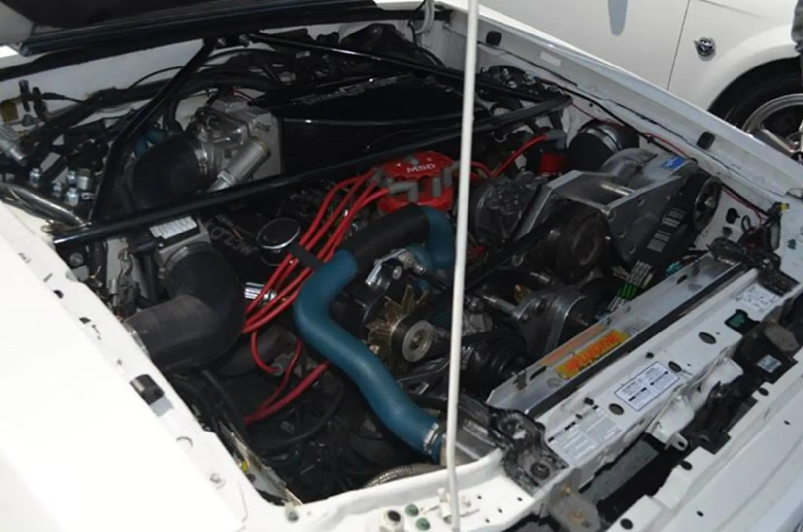 Car engine with red wires and blue hoses