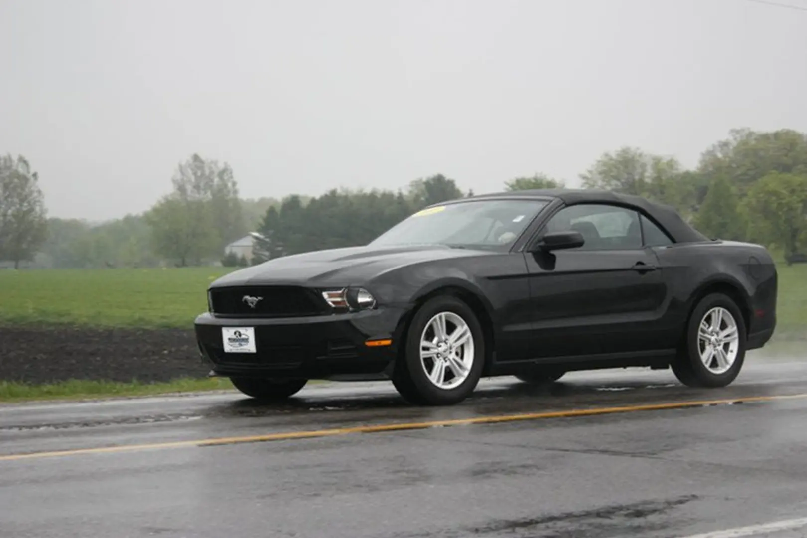 Sleek black car driving in rain